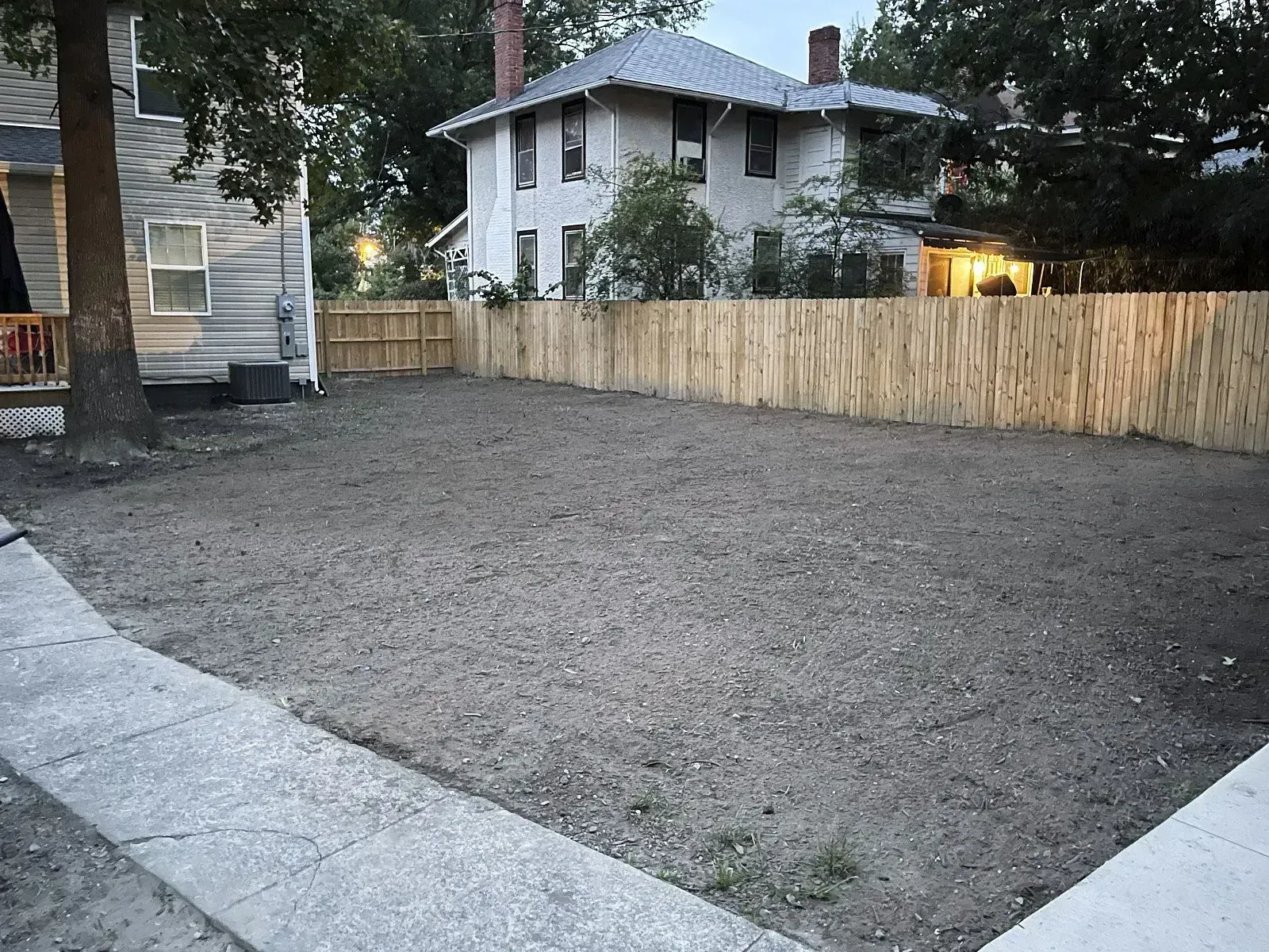 A clear lawn area outside a house undergoing professional yard leveling and landscape grading by a reputable grading company