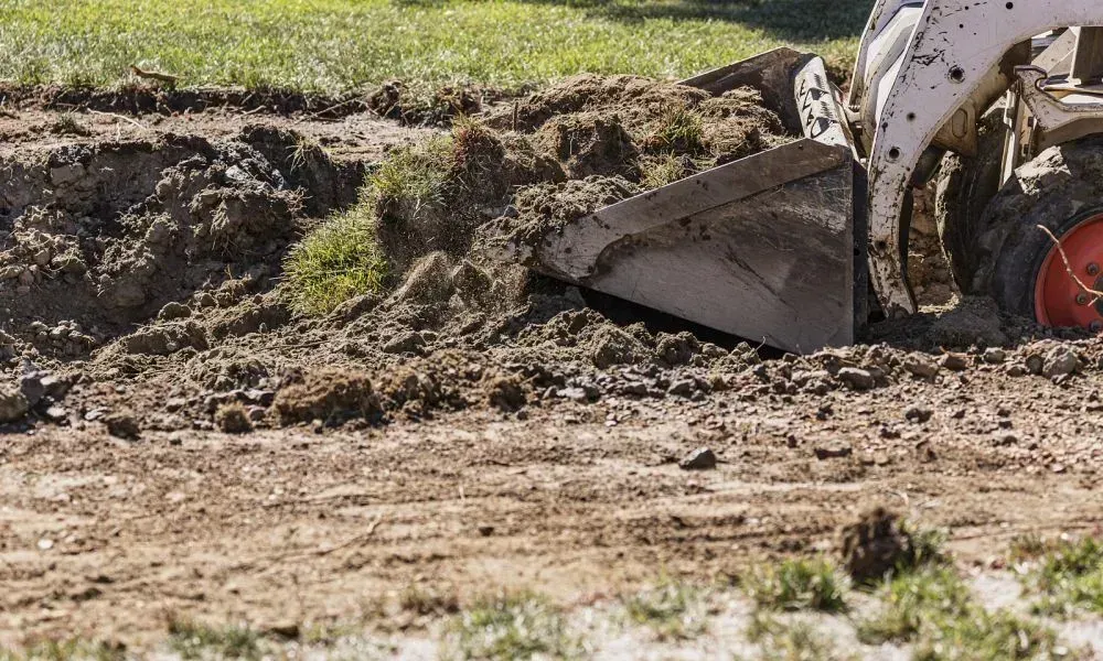A small bulldozer excavating and leveling the yard for improved landscape grading in the field