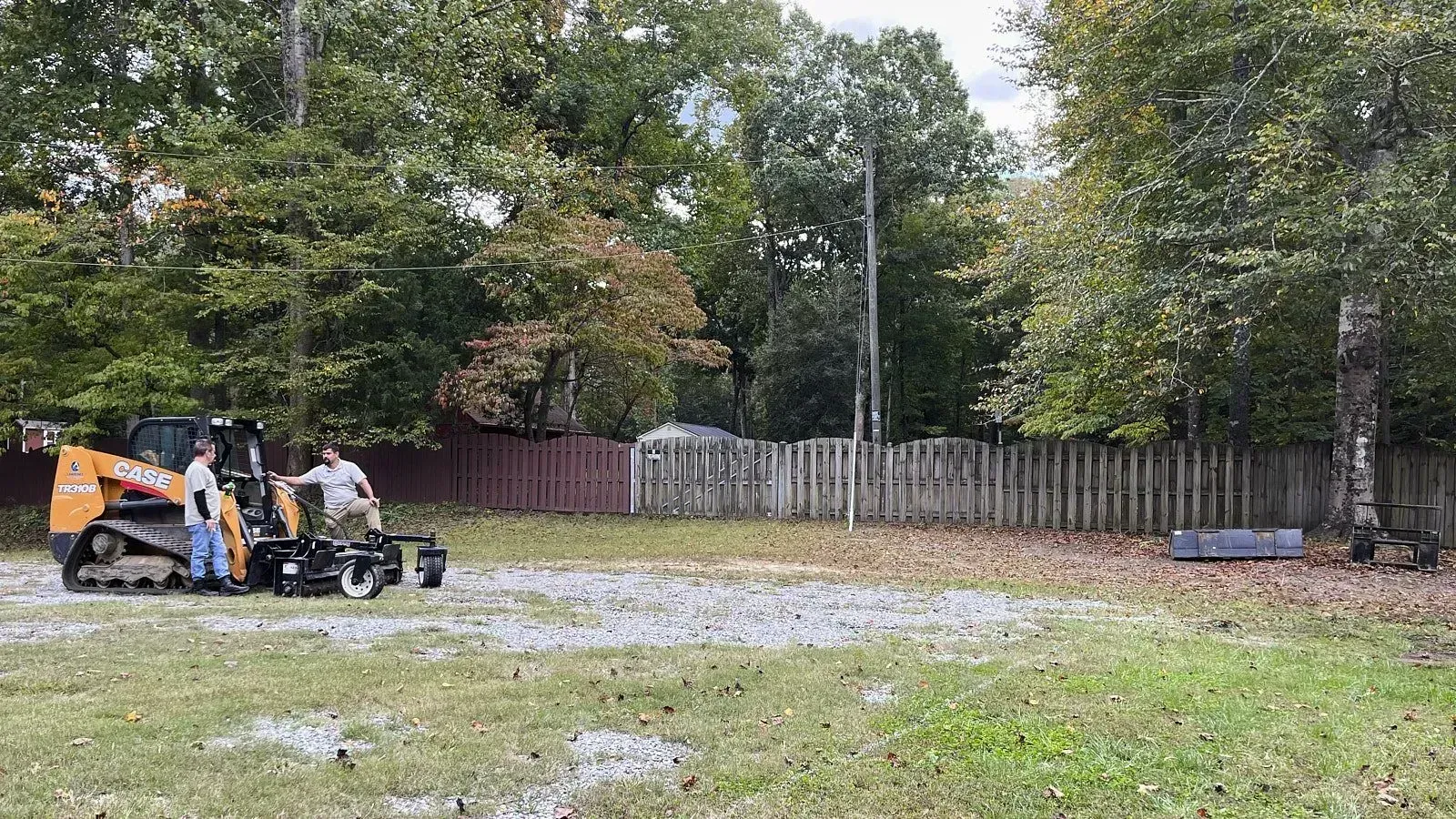 A wide angle shot of two landscape grading professionals discussing on the site before the yard leveling process
